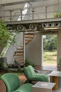 An industrial-style living room with wooden furniture and a spiral staircase.