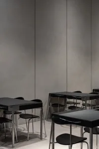 Modern, minimalist industrial restaurant interior with metal tables and chairs.
