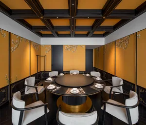 A modern, industrial-themed restaurant interior featuring a metal frame and round dining table surrounded by white upholstere