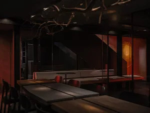 Industrial-style restaurant interior with wooden tables and seating.