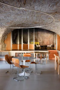 Modern library interior featuring stone, wood, and leather furniture and decor.