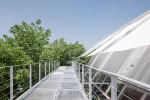 Modern outdoor corridor featuring a greenhouse roof and metal roofing