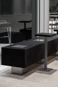 A modern public space furniture setup featuring concrete and metal elements.
