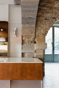A modern restaurant bar counter featuring stone, marble, and wood materials