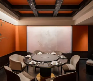 Modern restaurant private dining room with fabric chairs and wooden table.