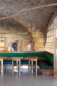 Modern restaurant interior with stone walls and contemporary seating.