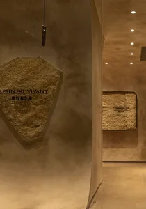 A modern storefront with a stone display window showcasing artisanal cookies.