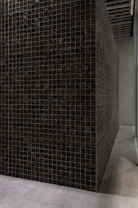 Close-up of a metal-mesh wall filled with dark, rectangular concrete pieces