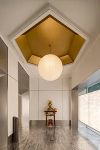 A modern sacred space with a white interior and a golden geometric ceiling.