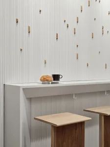A modern cafe interior featuring concrete and wooden elements.