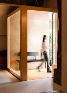 A modern interior space featuring glass walls and wooden accents.