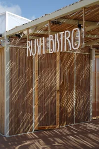 Bamboo exterior design of a restaurant with the sign 'Rush Bistro'.