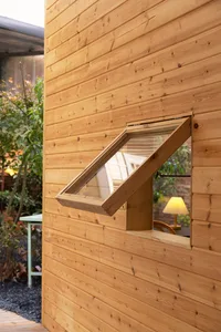 A contemporary window with a wooden frame and transparent glass, mounted on a wood-paneled wall.