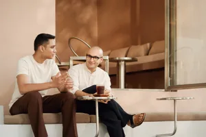 Two people sitting in a minimalist-designed coffee shop, engaged in a conversation.