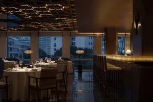 Modern interior design of a restaurant bar with marble and wood finishes.