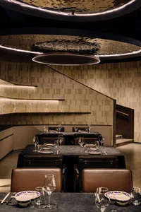 Modern restaurant interior with concrete walls and minimalist design.