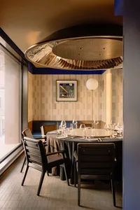 Modern interior design of a restaurant featuring wooden furniture, glass tableware, and tiled walls