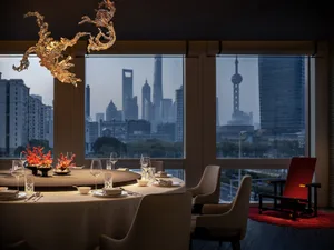 Industrially designed restaurant with glass chandeliers and a cityscape view.