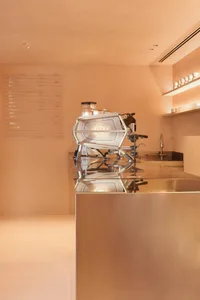 Modern coffee shop interior with a steel-clad counter top and minimalist design.