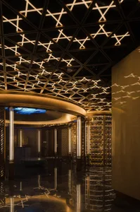 A modern wine bar with glass and metallic accents and illuminated lighting.