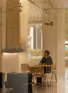 A modern cafe interior featuring wooden tables and metal chairs.