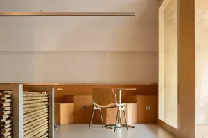 A minimalist interior space featuring cork, wood, and metal materials.