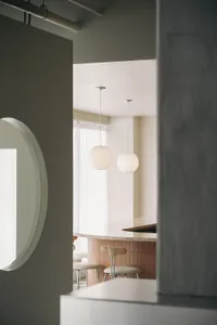 Modern, white-concrete restaurant interior with minimalist design.