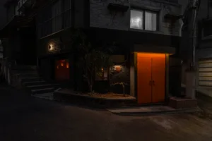 Night photograph of a building with brick and concrete exterior in urban setting.