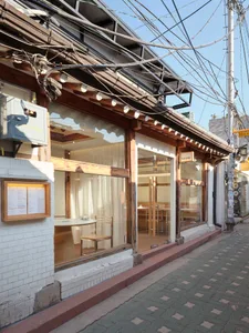 A retail storefront with wooden beams, glass windows, and metal railings.