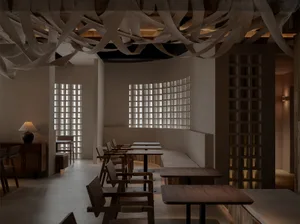 A cafe interior featuring wooden furniture and a grid-patterned window.