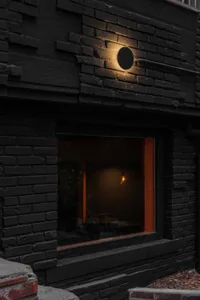 Modern home with black brick exterior at night.