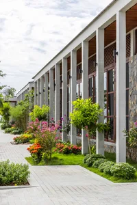 Modern hotel exterior featuring tall concrete columns and a vibrant garden space