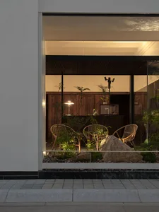A minimalist living room featuring wooden furniture and plants.