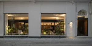 A modern retail storefront featuring a white marble exterior and a glass entrance.