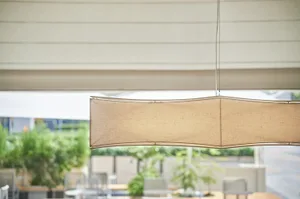 A modern coffee shop with a fabric lamp shade hanging from the ceiling, enhancing the interior design and ambiance of the spa