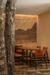 Industrially styled restaurant dining area featuring wooden furniture and walls with exposed wood