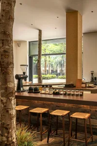 A minimalist coffee shop interior with wood surfaces and bar stools.