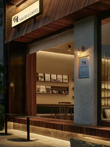 A modern industrial restaurant exterior with wooden accents, stone base, and metal signage.