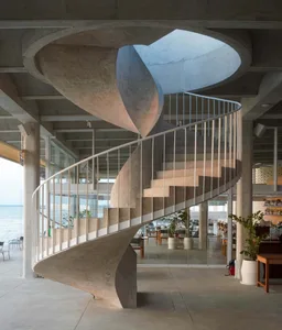 A modern interior design featuring a concrete staircase with a spiral pattern.