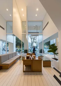 Modern restaurant interior with white concrete, wood, and glass elements.