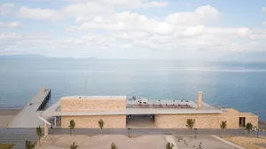 A modern architectural beach resort featuring sandstone and concrete structures.