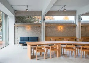 Modern cafe interior with wooden tables and concrete walls