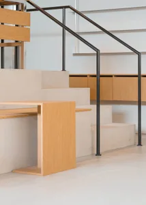 Modern interior design featuring a concrete staircase with wooden handrail and metal railing.