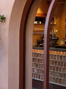 A modern restaurant bar with brick walls and concrete counter, showcasing sleek design elements and contemporary aesthetic.