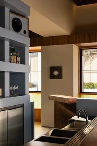 A modern kitchen with concrete countertops and a stainless steel sink.