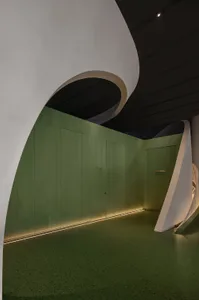 A modern interior space with green walls and concrete surfaces.