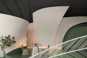A modern restaurant with concrete and adobe walls, featuring a table setup with two chairs.