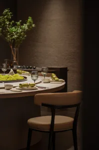 A modern restaurant interior with elegant dining setup and green plants.