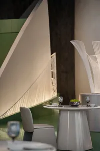 A modern restaurant interior with metal lighting fixtures, sleek tables, and minimalist chairs.