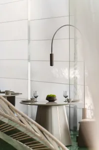 Modern dining room featuring a glass table with a metal base and minimalist decor.